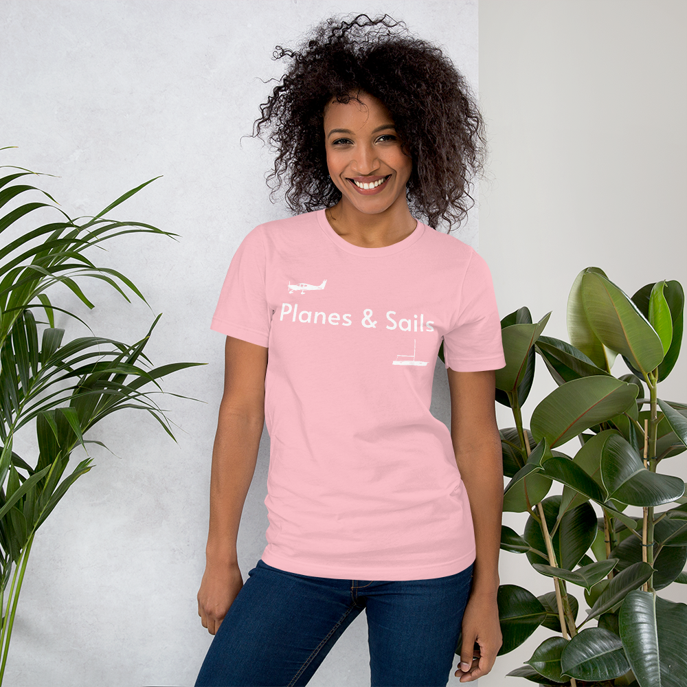 Pilots and mariners clothing: On a pink coloured tee shirt a white low wing single engine plane is printed on the right breast whereas there is a sailing boat below the left breast with the phrase planes and sails written inbetween the two.