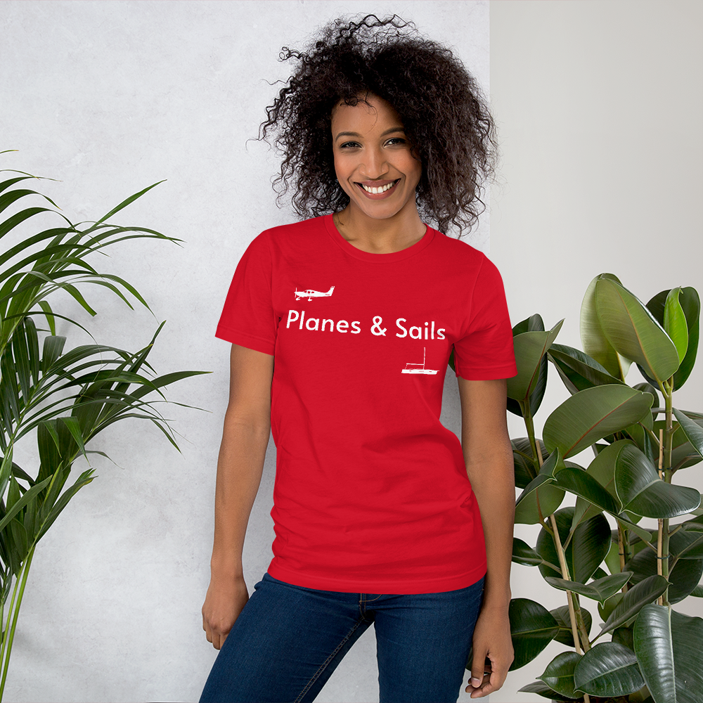 Pilots and mariners clothing: On a red coloured tee shirt a white low wing single engine plane is printed on the right breast whereas there is a sailing boat below the left breast with the phrase planes and sails written inbetween the two.