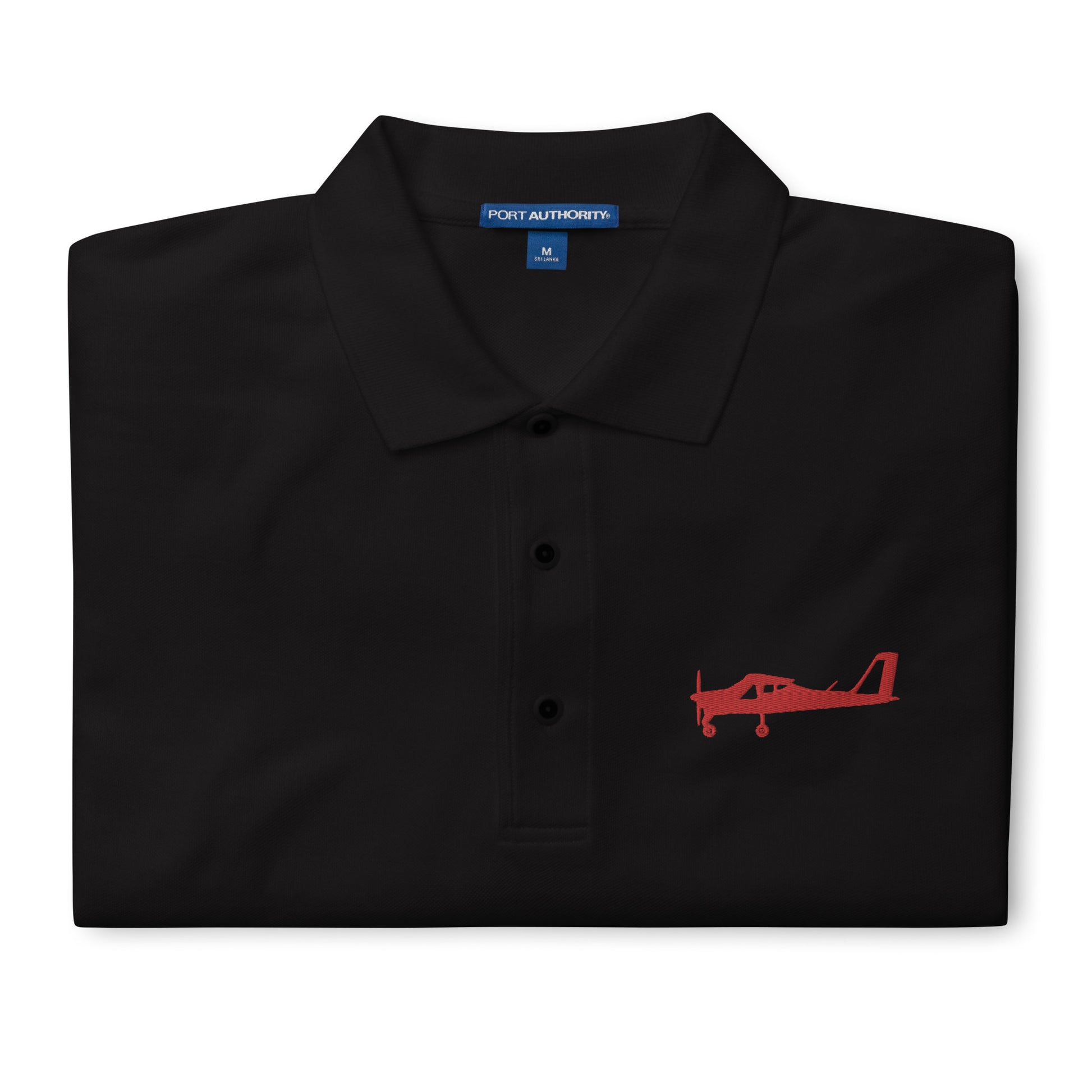 Red Tecnam P92 aircraft embroidered design placed on the left breast of a black colour polo shirt.