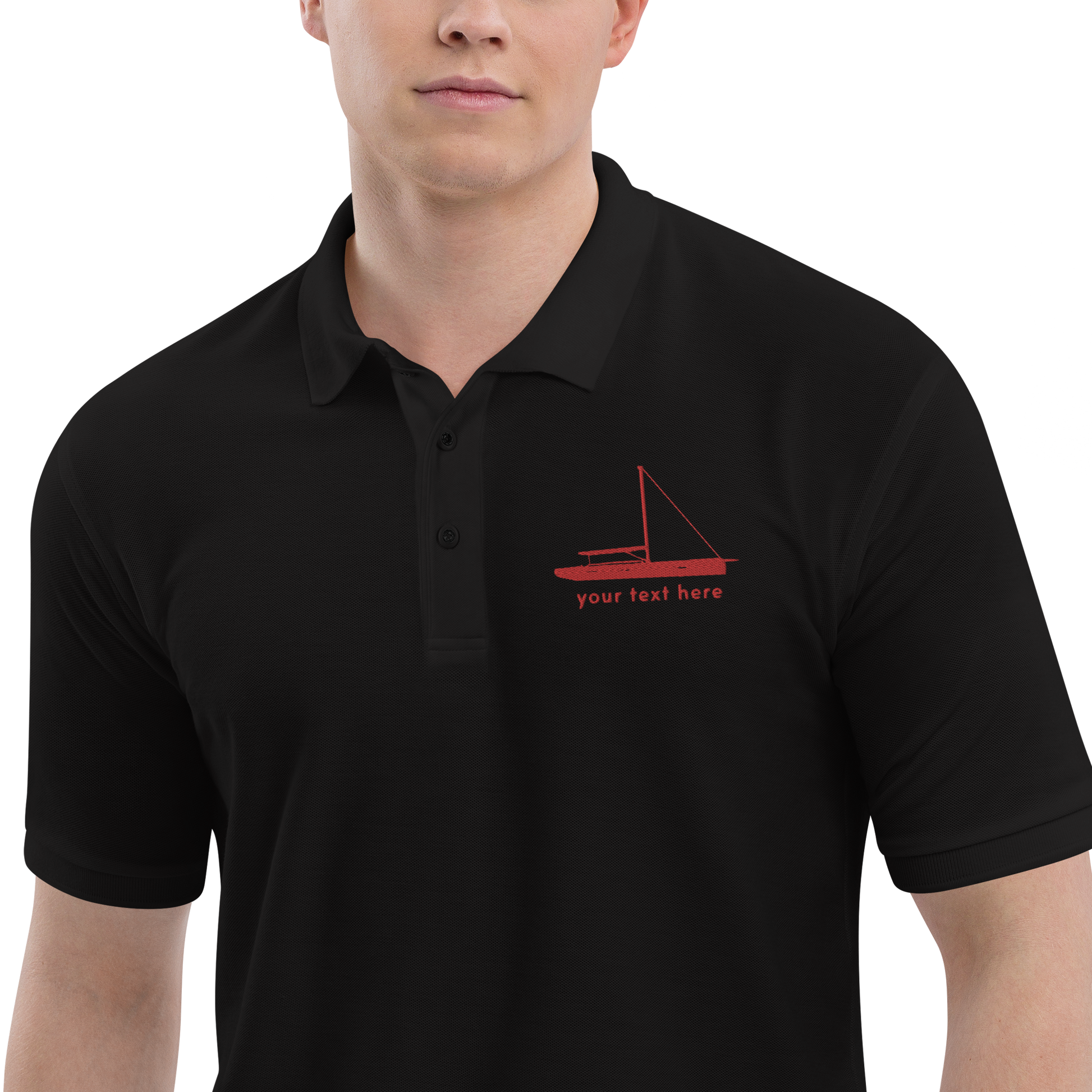 Sailing apparel: Black polo shirt with a red sloop rigged sailing boat placed over the left breast.