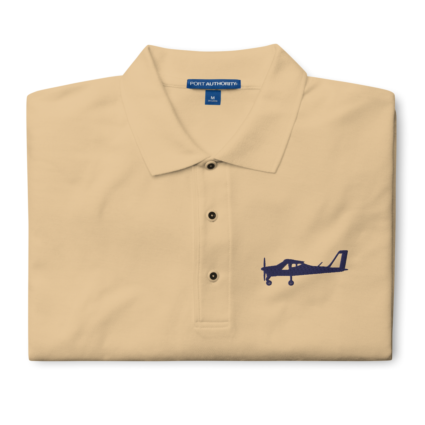 Navy blue Tecnam P92 aircraft embroidered design placed on the left breast of a beige polo shirt.