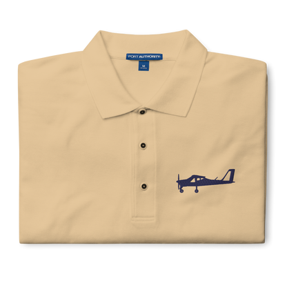 Navy blue Tecnam P92 aircraft embroidered design placed on the left breast of a beige polo shirt.