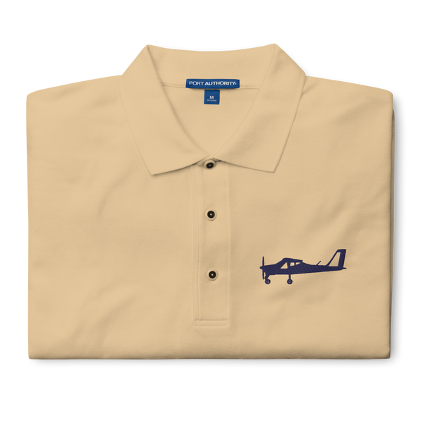 Navy blue Tecnam P92 aircraft embroidered design placed on the left breast of a beige polo shirt.