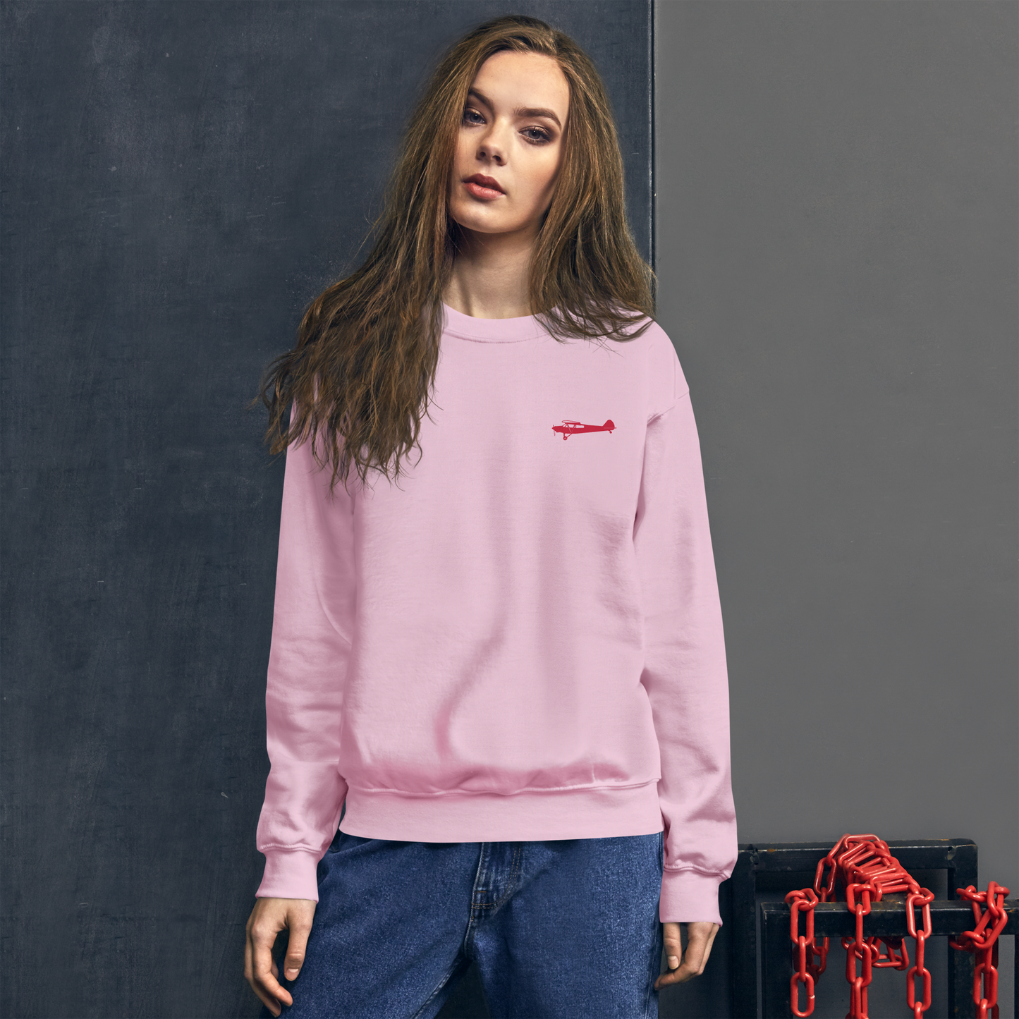 Pilots sweaters: Red Super Cub design positioned on the left breast of a pink sweatshirt.